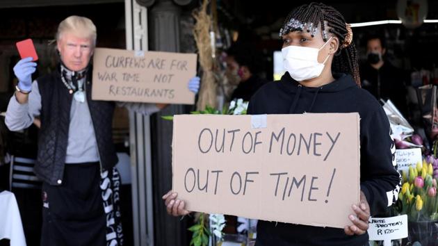 A woman holds a placard during a protest by members of the restaurant industry against the coronavirus disease restrictions in Johannesburg on July 22. President Ramaphosa implemented a tough lockdown at the end of March but a surge in poverty and unemployment in a country that already had too much of both spurred the government to partially lift restrictions before the peak of infections. (Siphiwe Sibeko / REUTERS) A woman holds a placard during a protest by members of the restaurant industry against the coronavirus disease restrictions in Johannesburg on July 22. President Ramaphosa implemented a tough lockdown at the end of March but a surge in poverty and unemployment in a country that already had too much of both spurred the government to partially lift restrictions before the peak of infections. (Siphiwe Sibeko / REUTERS)