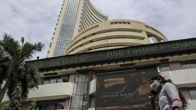 A pedestrian wearing a protective mask walks past the Bombay Stock Exchange (BSE) building in Mumbai.(Bloomberg) A pedestrian wearing a protective mask walks past the Bombay Stock Exchange (BSE) building in Mumbai.(Bloomberg)