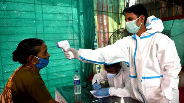A BMC health care worker checks temperature of a resident at Mankhurd during Covid-19 pandemic in Mumbai, July 25, 2020. (Satish Bate/HT Photo) A BMC health care worker checks temperature of a resident at Mankhurd during Covid-19 pandemic in Mumbai, July 25, 2020. (Satish Bate/HT Photo)