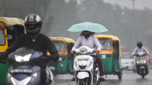 File photo of commuters out in the rain in New Delhi.(Sanchit Khanna/HT Photo)