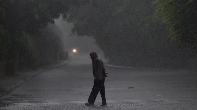 A man covers his head with a piece of cloth amid heavy rain at Nizamuddin in New Delhi. (Biplov Bhuyan/HT PHOTO) A man covers his head with a piece of cloth amid heavy rain at Nizamuddin in New Delhi. (Biplov Bhuyan/HT PHOTO)
