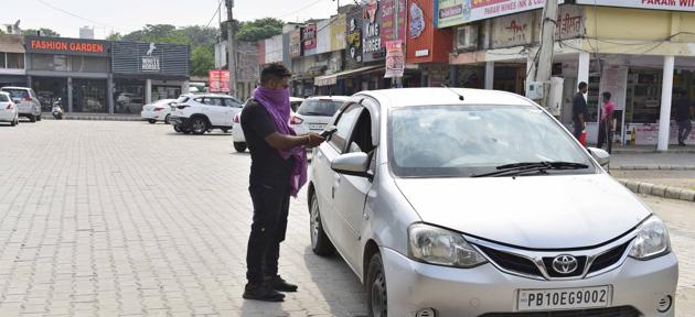 A visitor collecting a parking slip at a facility in BRS Nagar, Ludhiana, on Saturday. As per the prescribed rates, two-wheelers can be parked for ₹10 and four-wheelers for ₹20. (GURPREET SINGH/HT)