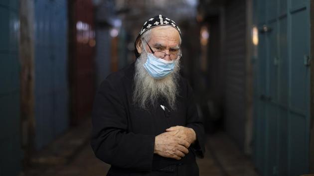 Syrian Orthodox priest Shimon Jan, poses in the alleys of Jerusalem's Old City on July 21. Jan said,”I'm advising to everyone to wear face masks not only because of the law also because life is the most important thing.” (Oded Balilty / AP) Syrian Orthodox priest Shimon Jan, poses in the alleys of Jerusalem's Old City on July 21. Jan said,”I'm advising to everyone to wear face masks not only because of the law also because life is the most important thing.” (Oded Balilty / AP)
