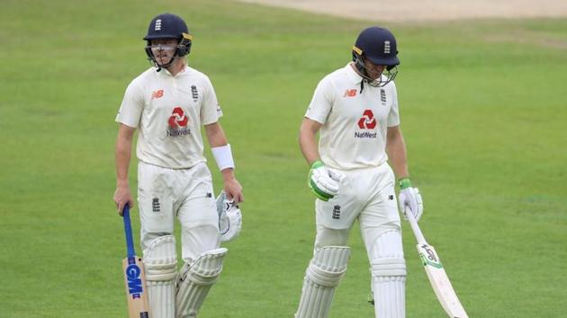 England's Ollie Pope and Jos Buttler walk off after play was ended for the day due to bad light. (REUTERS)