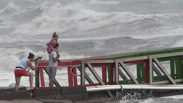 A girl covers her face from strong winds as her family members watch high swells from Hurricane Hanna from a jetty in Galveston, Texas, US on July 25, 2020. (Reuters Photo) A girl covers her face from strong winds as her family members watch high swells from Hurricane Hanna from a jetty in Galveston, Texas, US on July 25, 2020. (Reuters Photo)