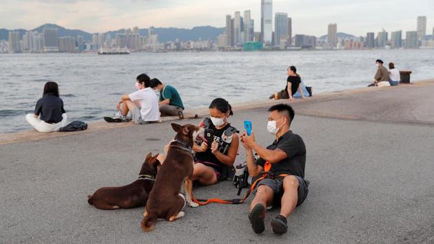 Elaine and Henry play with their dogs Ah Mui, Fa Fa and Cho Cho in Hong Kong on July 20. Henry told Reuters, he and Elaine “never imagined” they would be arrested. “We never thought we would need to find a lawyer, or who would take care of our dogs.” They were among the first to be charged with rioting during the protests last year, arrested with a 17-year-old named Natalie Lee. (Tyrone Siu / REUTERS)