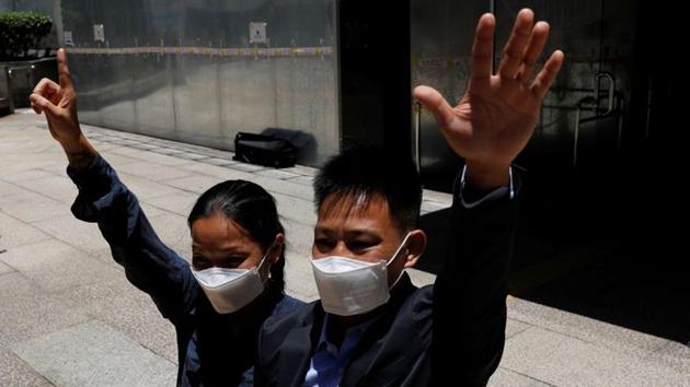Elaine and Henry raise their hands in the symbol of “Five demands, not one less” after being acquitted on rioting charges in Hong Kong on July 24. As they stood in the courthouse, the judge announced they had been acquitted of the rioting charge. The couple was found guilty of the lesser offence of possessing a wireless radio without a permit and fined $1,300 each. They were free to go. (Tyrone Siu / REUTERS)