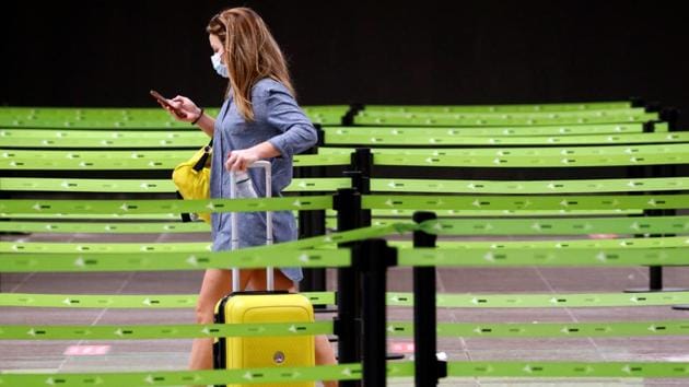 A passenger queues to check-in at Josep Tarradellas Barcelona-El Prat airport in Barcelona on July 26. Spain reported over 900 new daily infections on July 23 and 24 according to most recent data from the Spanish health ministry. The new outbreak prompted the UK on July 25 to reimpose quarantine on travellers returning from the country, dealing a new blow to its tourism dependent economy. (Albert Gea / REUTERS) 