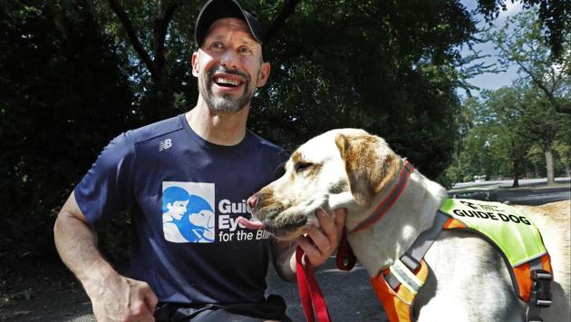 Thomas Panek pauses with his Labrador retriever, Blaze, a trained guide dog, after running in Central Park, Thursday, July 23, 2020, in New York.  (AP Photo/Kathy Willens) 