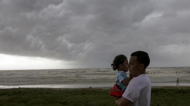 People walk along Seawall Boulevard as a band of heavy rain and wind approaches, in Galveston, Texas(AP) People walk along Seawall Boulevard as a band of heavy rain and wind approaches, in Galveston, Texas(AP)