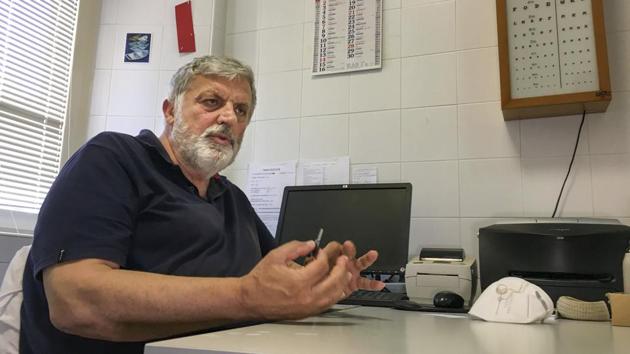 Armando Schiaffino, a native son and the island’s doctor for some 40 years now, talks with the Associated Press during an interview in his studio at the Giglio Island, Italy, Tuesday, June 23, 2020. (AP Photo/Paolo Santalucia)
