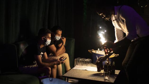 People wearing face masks to prevent the spread of coronavirus gather in a discotheque in Madrid on July 25. However, in Barcelona, nightclubs have been ordered shut for two weeks and there is a midnight curfew imposed on bars. A partial lockdown affecting 200,000 people has been already imposed in the western district of Segria. (Manu Fernandez / AP) 