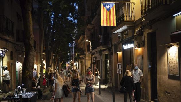 People walk at night in Gracia neighborhood in Barcelona on July 24. Catalonia’s regional government, run by separatists who had complained about Spain’s centralization of the health crisis from March to June, is struggling to maintain tabs on the growing clusters that have overwhelmed undermanned contact tracing teams. (Felipe Dana / AP) 