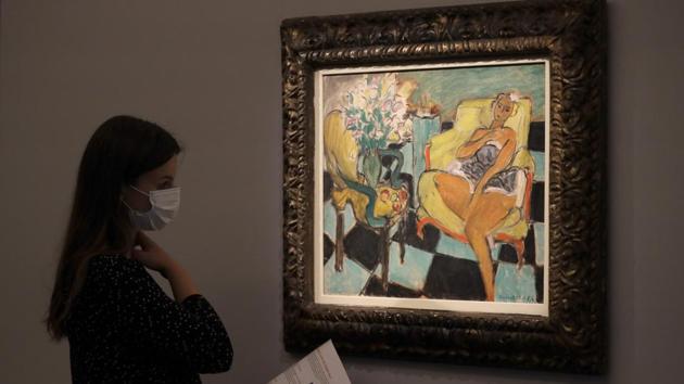 A Sotheby's employee looks towards a painting by Henri Matisse called 'Danseuse assise dans un fauteuil' at Sotheby's auction rooms in London. (AP Photo/Kirsty Wigglesworth)