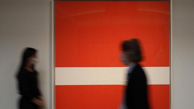 People walk past a painting by Ellsworth Kelly called 'Red White' at Sotheby's auction rooms in London, Thursday, July 23, 2020. (AP Photo/Kirsty Wigglesworth)