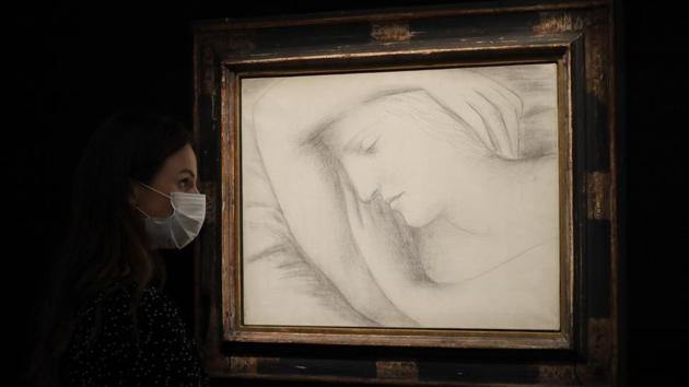 A Sotheby's employee looks towards a painting by Pablo Picasso called 'Femme endormie' at Sotheby's auction rooms in London. (AP Photo/Kirsty Wigglesworth)