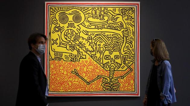 Visitors look at a painting by Keith Haring called 'Untitled' at Sotheby's auction rooms in London. (AP Photo/Kirsty Wigglesworth)