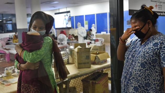 A visitor gets emotional seeing her Covid-19 positive relative with her newborn inside the Common Wealth Games Village Sports Complex (CWG) COVID-19 Care Centre, in New Delhi.(Ajay Aggarwal /HT PHOTO) A visitor gets emotional seeing her Covid-19 positive relative with her newborn inside the Common Wealth Games Village Sports Complex (CWG) COVID-19 Care Centre, in New Delhi.(Ajay Aggarwal /HT PHOTO)