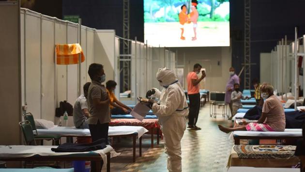 A Covid-19 patient reports to a health worker at the CWG Sports Complex Covid-19 Care Centre on July 24. 6,976 active patients have currently been kept in home isolation in the capital, while over 3,000 people who arrived here on Vande Bharat Mission and bubble flights have been accommodated in dedicated Covid care centres. (Sanchit Khanna / HT Photo)