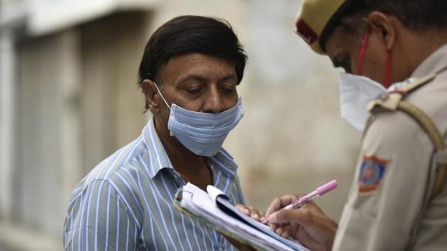 A Delhi Police personnel issues a challan to a commuter for not taking adequate measures to fight against coronavirus (Covid-19) disease, at Gole Market, in New Delhi.(Biplov Bhuyan/HT PHOTO) A Delhi Police personnel issues a challan to a commuter for not taking adequate measures to fight against coronavirus (Covid-19) disease, at Gole Market, in New Delhi.(Biplov Bhuyan/HT PHOTO)