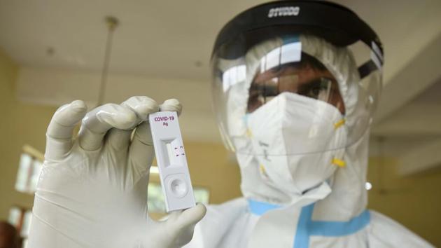 A health worker shows a coronavirus (COVID-19) rapid antigen test kit during a testing drive at the Community Center in Sector-9 A, Gurugram.(Parveen Kumar/Hindustan Times)