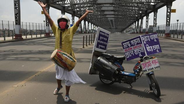 A man with a drum performs to raise awareness about using face masks and social distancing on Rabindra Setu in Kolkata on July 25. India’s coronavirus epidemic is now growing at the fastest in the world, increasing 20% over the last week to more than 1.4 million confirmed cases, according to Bloomberg’s Coronavirus Tracker. (Samir Jana / HT Photo)