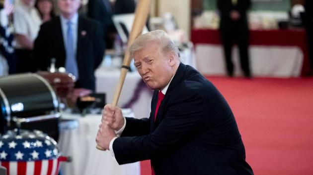 U.S. President Donald Trump swings a baseball bat during the 'Spirit of America Showcase' at the White House in Washington.(Bloomberg)