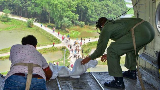 An Air Force personnel and a volunteer drop relief materials from a helicopter in Darbhanga district on July 26. Air-drops of food packets by the IAF have been paused in Gopalganj, Darbhanga and East Champaran districts due to the worsening situation and weather. The operation had started in these places on July 25. 17 NDRF teams are meanwhile involved in Bihar on the ground. (PTI)