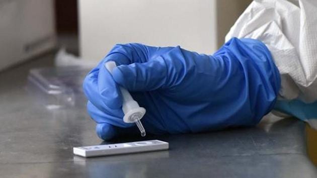 A health worker works with a rapid antigen based Covid-19 test kit(Hindustan Times) A health worker works with a rapid antigen based Covid-19 test kit(Hindustan Times)