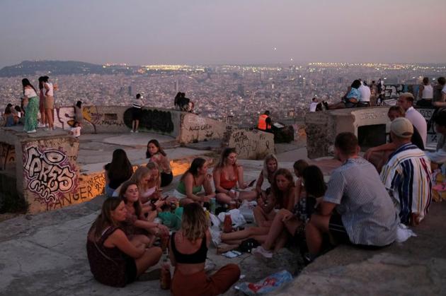 Tourists and locals gather at a lookout point, with a view of the city of Barcelona in the background, after regional authorities across Spain introduced fresh coronavirus disease (COVID-19) restrictions aimed at stamping out a surge in infections, in Barcelona. (REUTERS) Tourists and locals gather at a lookout point, with a view of the city of Barcelona in the background, after regional authorities across Spain introduced fresh coronavirus disease (COVID-19) restrictions aimed at stamping out a surge in infections, in Barcelona. (REUTERS)