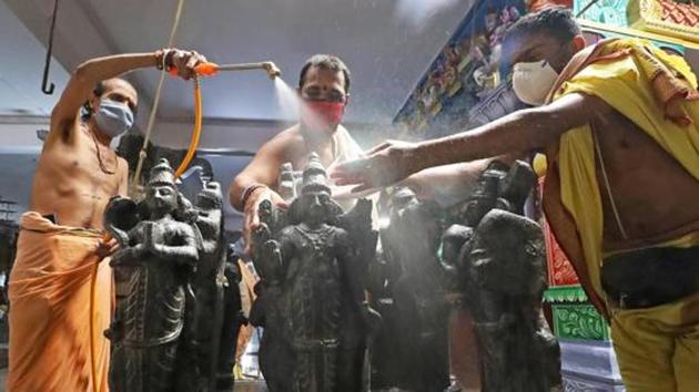 Priests spray disinfectant on the idols of deities at a temple ahead of its re-opening for devotees during the Covid-19 lockdown in Bengaluru on June 6, 2020.(PTI File Photo) Priests spray disinfectant on the idols of deities at a temple ahead of its re-opening for devotees during the Covid-19 lockdown in Bengaluru on June 6, 2020.(PTI File Photo)