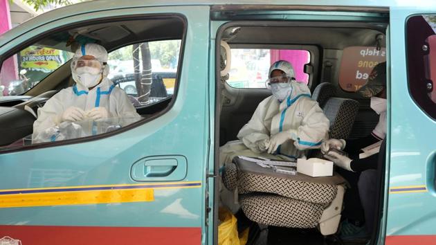 Health workers prepare to conduct rapid-antigen methodology Covid-19 tests from a testing vehicle at a healthcare centre in New Delhi.(Bloomberg)