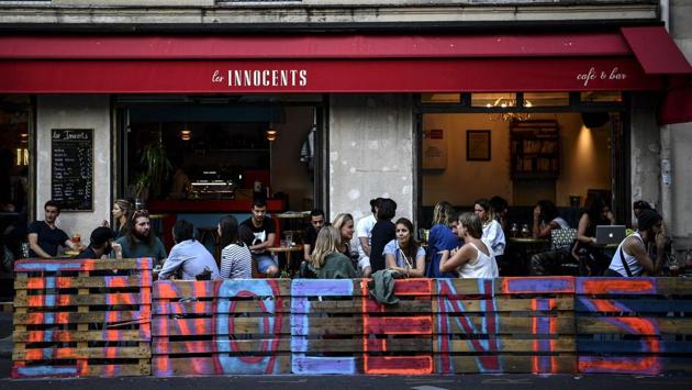 People have drinks at a makeshift patio in Paris on July 22. “There’s been some real creativity, a real ambition that has transformed some neighbourhoods,” Deputy mayor in charge of public space and transport, David Belliard told AFP. (Christophe Archambault / AFP)