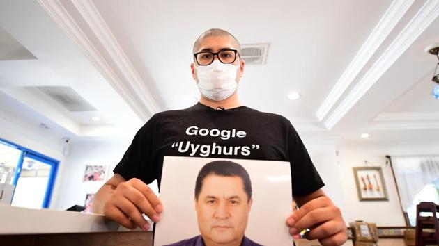 Bugra Arkin, son of publisher Arkin Ibrahim who went missing the end of October 2018, holding a photo of his father, at his Uyghur restaurant in Alhambra, California.(AFP)