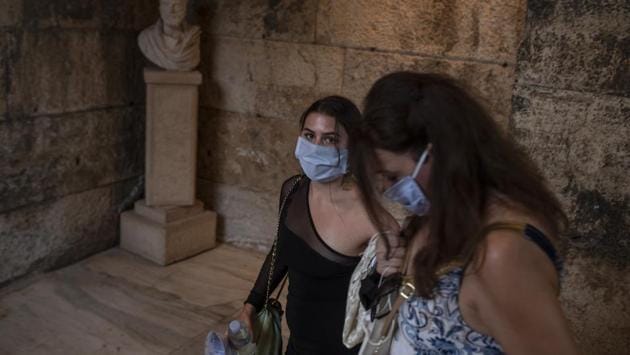 Spectators wearing protective face masks to prevent the spread of the coronavirus arrive at the Odeon of Herodes Atticus in Athens. (AP Photo/Petros Giannakouris) Spectators wearing protective face masks to prevent the spread of the coronavirus arrive at the Odeon of Herodes Atticus in Athens. (AP Photo/Petros Giannakouris)