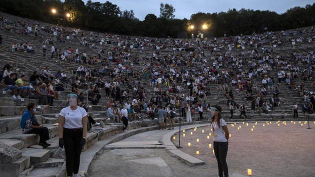 Stewards wearing surgical gloves and plastic visors stands as spectators take their seats at the ancient theater of Epidaurus, Greece. (AP Photo/Petros Giannakouris) Stewards wearing surgical gloves and plastic visors stands as spectators take their seats at the ancient theater of Epidaurus, Greece. (AP Photo/Petros Giannakouris)