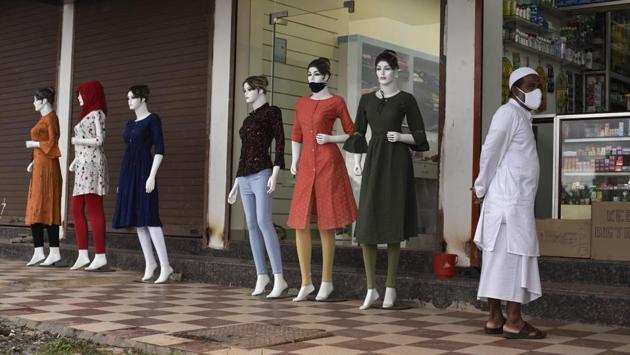 A man wearing a face mask stands outside a clothing store in Kochi on July 24. While Maharashtra, Tamil Nadu, Andhra Pradesh continue to report the majority of cases, India has been ramping up testing, with a record 528,082 samples taken on July 27, according to the Indian Council of Medical Research (ICMR). (R S Iyer / AP)