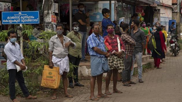 People wearing masks as a precaution against the coronavirus virus wait for transportation in Kochi, Kerala.(AP) People wearing masks as a precaution against the coronavirus virus wait for transportation in Kochi, Kerala.(AP)