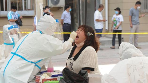 A health worker carries out a coronavirus test on a resident at a makeshift testing centre in Dalian on July 28. According to AFP’s report, six more cases were reported on July 28, in the industrial port city of Dalian, where a new outbreak first emerged at a seafood processing plant last week, bringing the total number of new infections in Dalian to 44. (STR / AFP) A health worker carries out a coronavirus test on a resident at a makeshift testing centre in Dalian on July 28. According to AFP’s report, six more cases were reported on July 28, in the industrial port city of Dalian, where a new outbreak first emerged at a seafood processing plant last week, bringing the total number of new infections in Dalian to 44. (STR / AFP)