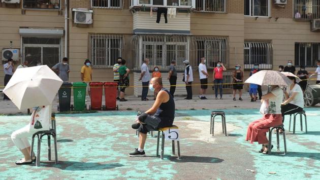 People sit socially distanced on chairs as they wait to undergo coronavirus tests at a makeshift testing centre in Dalian, China on July 28. A fresh coronavirus cluster in Dalian has spread to other provinces and prompted fresh restrictions, authorities told AFP. (STR / AFP) People sit socially distanced on chairs as they wait to undergo coronavirus tests at a makeshift testing centre in Dalian, China on July 28. A fresh coronavirus cluster in Dalian has spread to other provinces and prompted fresh restrictions, authorities told AFP. (STR / AFP)