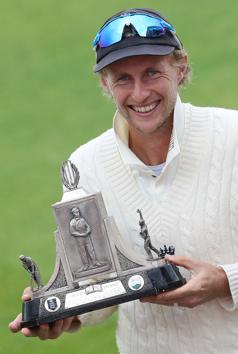 England's captain Joe Root holds aloft the Wisden Trophy after England won the Test series 2-1 against the West Indies, at the end of the final day of the third Test cricket match between England and the West Indies at Old Trafford in Manchester, northwest England on July 28, 2020. - England beat the West Indies by 269 runs on Tuesday to claim the third Test at Old Trafford and clinch the series. England took the series 2-1 to regain the Wisden Trophy they lost in the Caribbean last year. (Photo by Martin Rickett / POOL / AFP) / RESTRICTED TO EDITORIAL USE. NO ASSOCIATION WITH DIRECT COMPETITOR OF SPONSOR, PARTNER, OR SUPPLIER OF THE ECB (AFP)