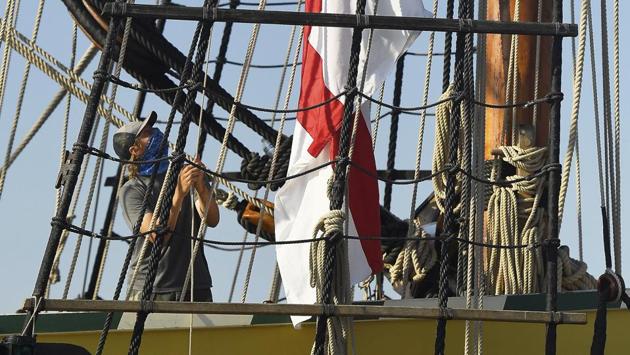 Crew member Max Otto prepares to raise the Cross of St. George flag during morning colours on board the Mayflower II docked at City Pier in New London, Conn., Tuesday, July 28, 2020, on the seventh day of two weeks of sea trials. (AP) Crew member Max Otto prepares to raise the Cross of St. George flag during morning colours on board the Mayflower II docked at City Pier in New London, Conn., Tuesday, July 28, 2020, on the seventh day of two weeks of sea trials. (AP)