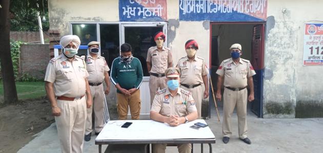 Manpreet Singh (third from left) has been arrested in Ludhiana for posing as a food supplies official and demanding money from shopkeepers.(HT Photo)