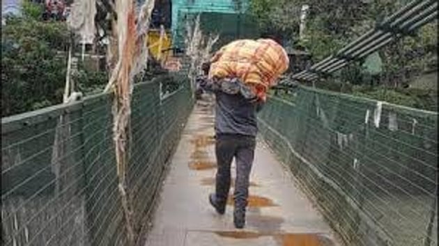 A Nepalese man crosses a bridge in Dharchula in Uttarakhand to enter Nepal.((HT FILE PHOTO)