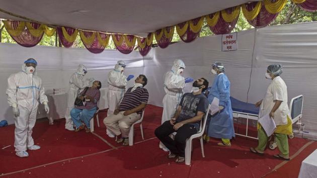 Healthcare workers in PPE kits perform rapid antigen tests at a swab collection center on Sinhgad road in Pune. (Pratham Gokhale/HT Photo) Healthcare workers in PPE kits perform rapid antigen tests at a swab collection center on Sinhgad road in Pune. (Pratham Gokhale/HT Photo)