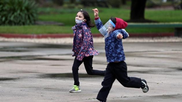 Children wearing protective face coverings play at a park as the government begins to ease quarantine restrictions imposed to slow the spread of the coronavirus disease (COVID-19), in Buenos Aires, Argentina. (REUTERS)