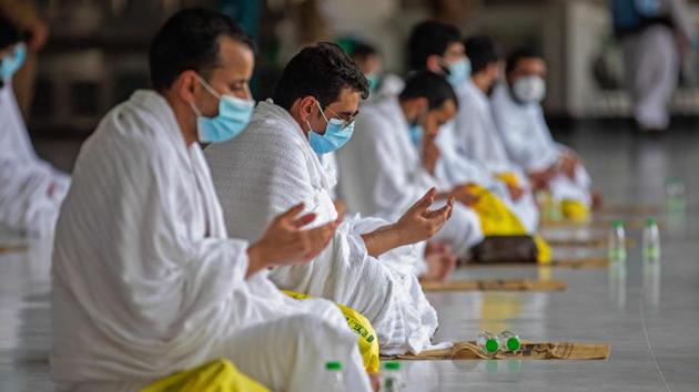 Muslim pilgrims wearing protective masks pray at the Grand Mosque in Mecca on July 29. Normally, religious tourism -- of which hajj is only a part -- brings in revenue equivalent to about 2.7% of Saudi Arabia’s GDP. But the crowds of people from all over the world are also potential incubators of disease, so the government halted them at the start of the pandemic, Bloomberg reported. (Saudi Ministry of Media  / AFP) 