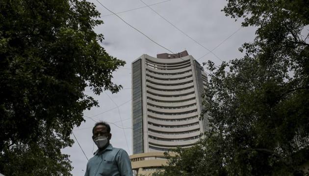 A pedestrian wearing a protective mask walks near the Bombay Stock Exchange (BSE) building in Mumbai.(Bloomberg)