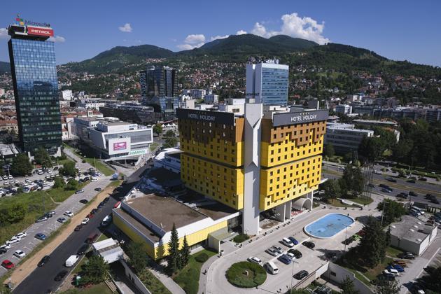 The Holiday Hotel, which opened as Holiday Inn, a luxurious accommodation for world's royalty, film stars and other dignitaries who came to watch the 1984 Winter Olympics, and less than a decade later, became ground zero of the bloody siege of Sarajevo in the 1990's, photographed from a nearby building, in Sarajevo, Bosnia, Wednesday, July 29, 2020. (AP)