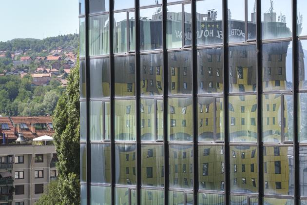 The Holiday Hotel, which opened as Holiday Inn, is reflected in the windows of a nearby building in Sarajevo, Bosnia, Wednesday, July 29, 2020. (AP)